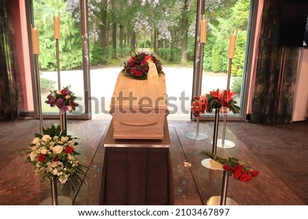 A coffin with a flower arrangement in a morgue, a funeral service