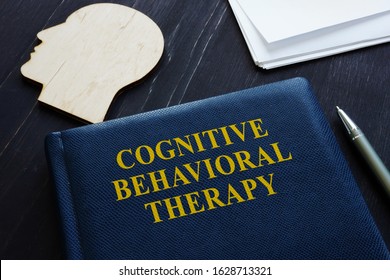 Cognitive Behavioral Therapy CBT Book And Wooden Head Shape.