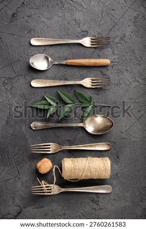 A cohesive collection of rustic kitchen flat-lay compositions featuring vintage silverware, assorted spices, herbs, coarse salt, peppercorns, nuts, dried chili, star anise, wooden utensils, ceramic tableware, greenery, fern leaves, and natural twine. The series showcases antique forks, spoons, knives, and ladles arranged on a dark textured stone background in creative patterns and styled culinary scenes. From minimal utensil lineups to botanical and handcrafted accents, this versatile collection is ideal for culinary branding, food styling, recipe blogs, restaurant graphics, menu layouts, and traditional cooking themes.