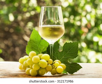 Coid White Wine And Green Grapes On Natural Blurred Background With Bokeh, Selective Focus