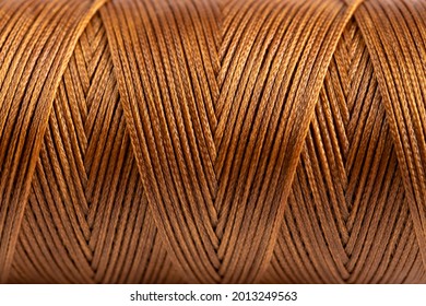 A coil of brown thread. Spool of colored threads on a white background. Waxed sewing thread for leather crafts. - Powered by Shutterstock