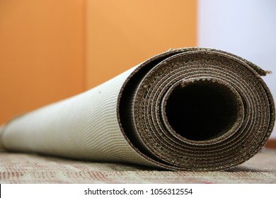 a coil of brown wall to wall office carpet placed on the installed office carpet