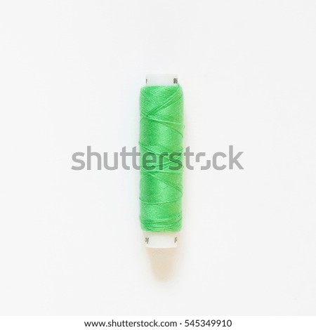 The coil with green threads. White background.