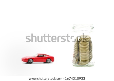  A lot of coil in jar with blurry red car beside on white background  meaning saving for big goal