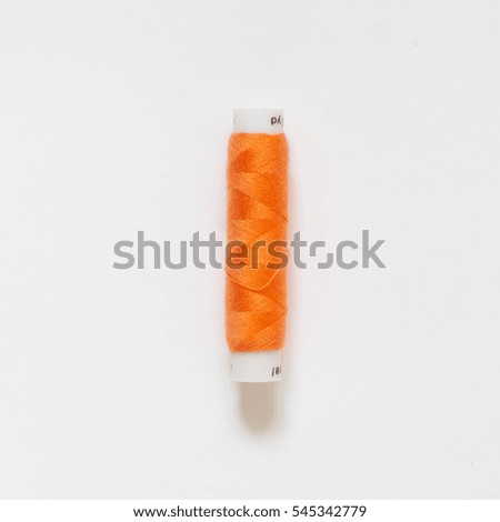 The coil with orange threads. White background.