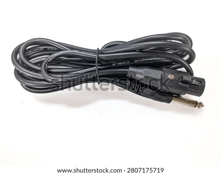 Coiled black microphone cable with XLR female to 6.35mm TS mono jack plug isolated on a white background