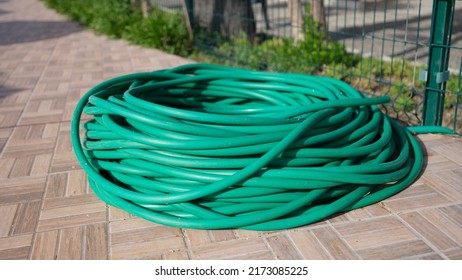 Coiled Garden Hose Lies On Ground Closeup