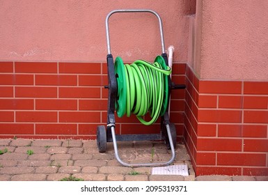 Coiled Garden Hose Next To The Building