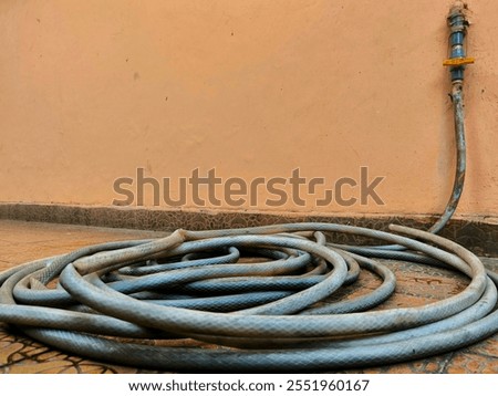 Similar – Image, Stock Photo Garden hose lies on a square terrace of stone tiles in a well-kept garden with lawn and a planting strip