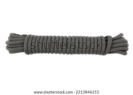 Coiled nylon rope isolated on white background. Striped nylon rope isolated. A coil of new black rope.