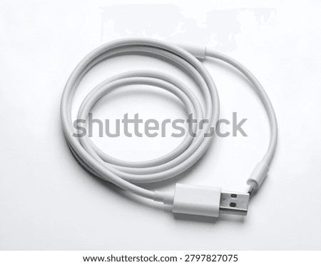 Coiled white cable on a white surface, with USB connector on the end