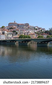 Coimbra city and Santa Clara bridge over Mondego river at Central district in Portugal, clear blue sky in 2022 warm sunny spring day on May - vertical - Shutterstock ID 2173889637