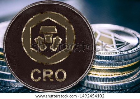 Coin cryptocurrency Crypto Chain Com CRO on the background of a stack of coins.