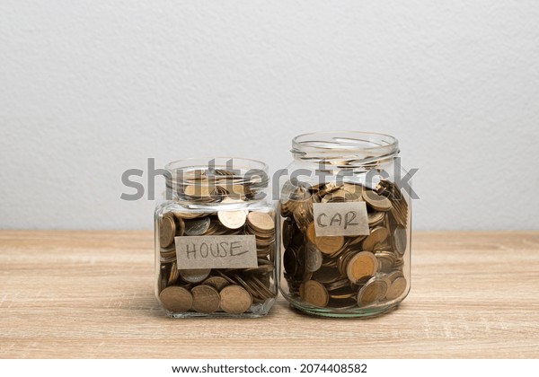 Coin in a glass jar for saving\
money on the brown table and copy space for financial\
concept