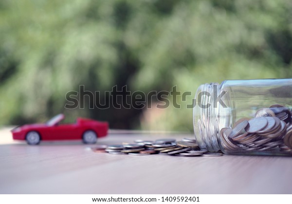 Coin jar and car model Represents the debt\
from buying a car. debt or save\
concept
