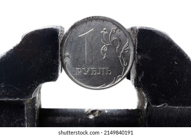 Coin one Russian ruble clamped by a black metal vice isolated on white background. Concept of financial and business problems. Russia economy under global sanctions