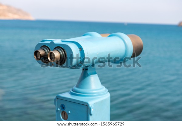 Coin operated binocular looking to the sea\
and Spinalonga Island on Crete,\
Greece.