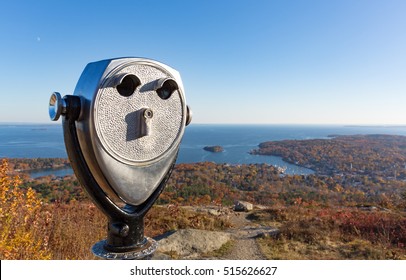 Coin operated binoculars in the foreground with Camden Maine harbor in the distance from Mt. Battie in the late fall.