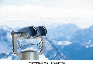 Coin Operated Binoculars With Snowy Mountains In The Background - Concept For Business Outlook Or Future Perspective