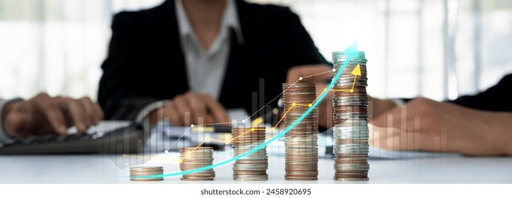 Coin stack with digital graphic indicator symbolizing business investment and economic growth. Businessman doing financial planning to achieve financial goal and contribute to profit. Shrewd
