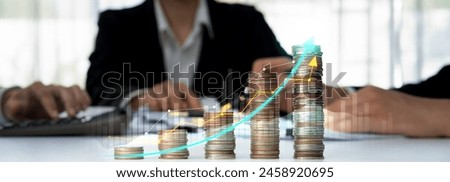 Coin stack with digital graphic indicator symbolizing business investment and economic growth. Businessman doing financial planning to achieve financial goal and contribute to profit. Shrewd
