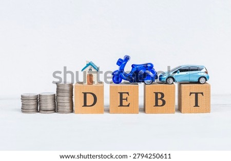 Coin stack with house and car model on wooden cube with dept message on white background, personal financial concept