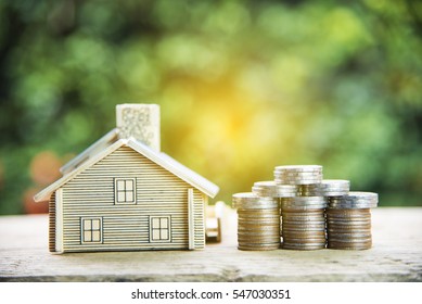 coin stack with house model, savings plans for housing ,green background, financial concept