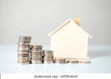 Coin stack and house plans. Property investment and house mortgage financial concept.
