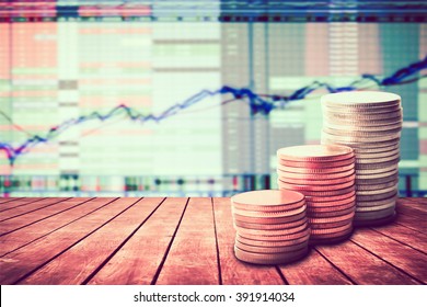 Coin Stack On Old Wooden Floor With Blur Image Of Graph Stock Market Background