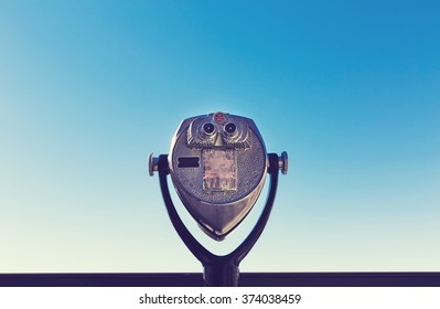 Coin-operated binoculars against the blue sky