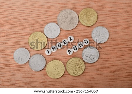 Coins and alphabet beads with text INDEX FUND. An index fund is a type of mutual fund or exchange-traded fund (ETF)