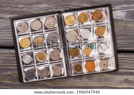 Coins collection on wooden desk. Top view flat lay.