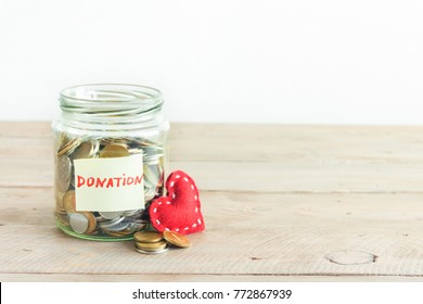 Coins In Glass Jar With Donation Label And Red Heart. Money Savings, Charity And Donation Concept, Copy Space.