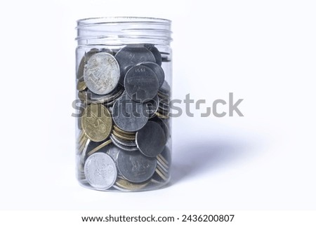 Coins in glass jar isolated on white background with copy space. Saving money concept.