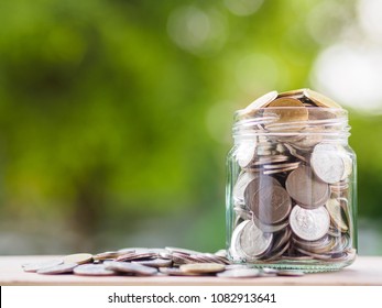 Coins in glass jar on blur background. money saving financial concept
