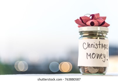 Coins In Glass Jar With The Word Christmas Money Saving With Bokeh Background