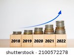 Coins increasing trend on woodblocks with identify years 2018-2022, Increasing trends concept