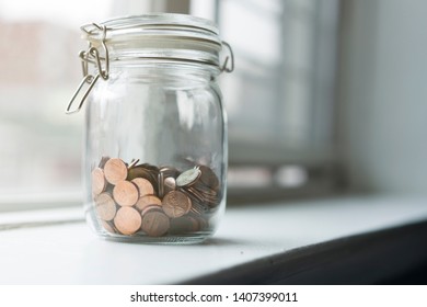 Lot Of Coins In A Jar By A Window In Sunset Time