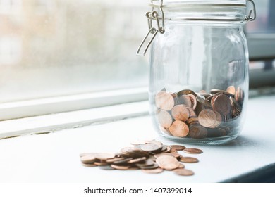 Lot Of Coins In A Jar By A Window In Sunset Time