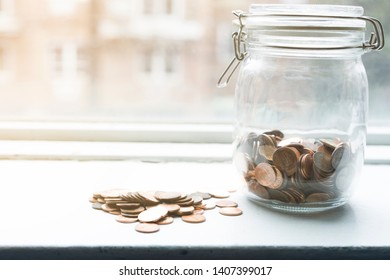 Lot Of Coins In A Jar By A Window In Sunset Time