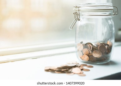 Lot Of Coins In A Jar By A Window In Sunset Time