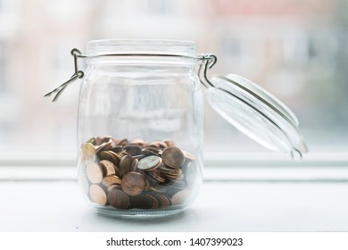 Lot Of Coins In A Jar By A Window In Sunset Time