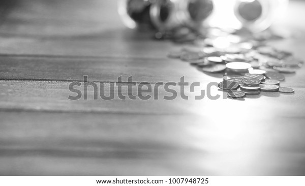 Coins in a jar on the floor.\
Accumulated coins on the floor. Pocket savings in\
piles.