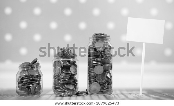 Coins in a jar on the floor.\
Accumulated coins on the floor. Pocket savings in\
piles.\