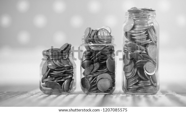 Coins in a jar on the floor.\
Accumulated coins on the floor. Pocket savings in\
piles.\