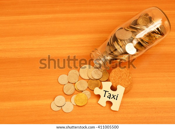 coins in the jar and puzzle with word taxi.\
Financial concept