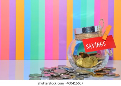 Coins In Jar With Savings Label With Multi Color Background - Financial Concept