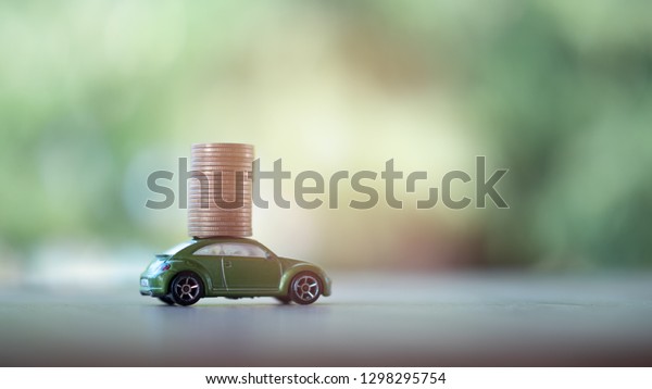 Coins money with car model on nature green\
background. Finance and car loan, refinance, Investment and\
business concept. with copy\
space