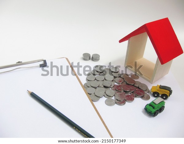 Coins\
money, house, paper and pencil show that planning for buying house\
is important before making decision. Saving and spending is\
important too. Business and insurance\
concept.