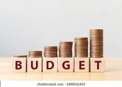 Coins on stack stair as step growing growth and wooden cube block with word BUDGET. Money annual budget concept - Shutterstock ID 1400531453
